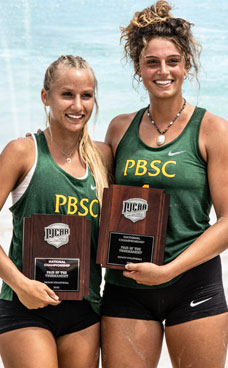 Two players from the PBSC volleyball team hold championship trophy